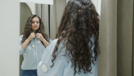 woman trying clothes on in a fitting room