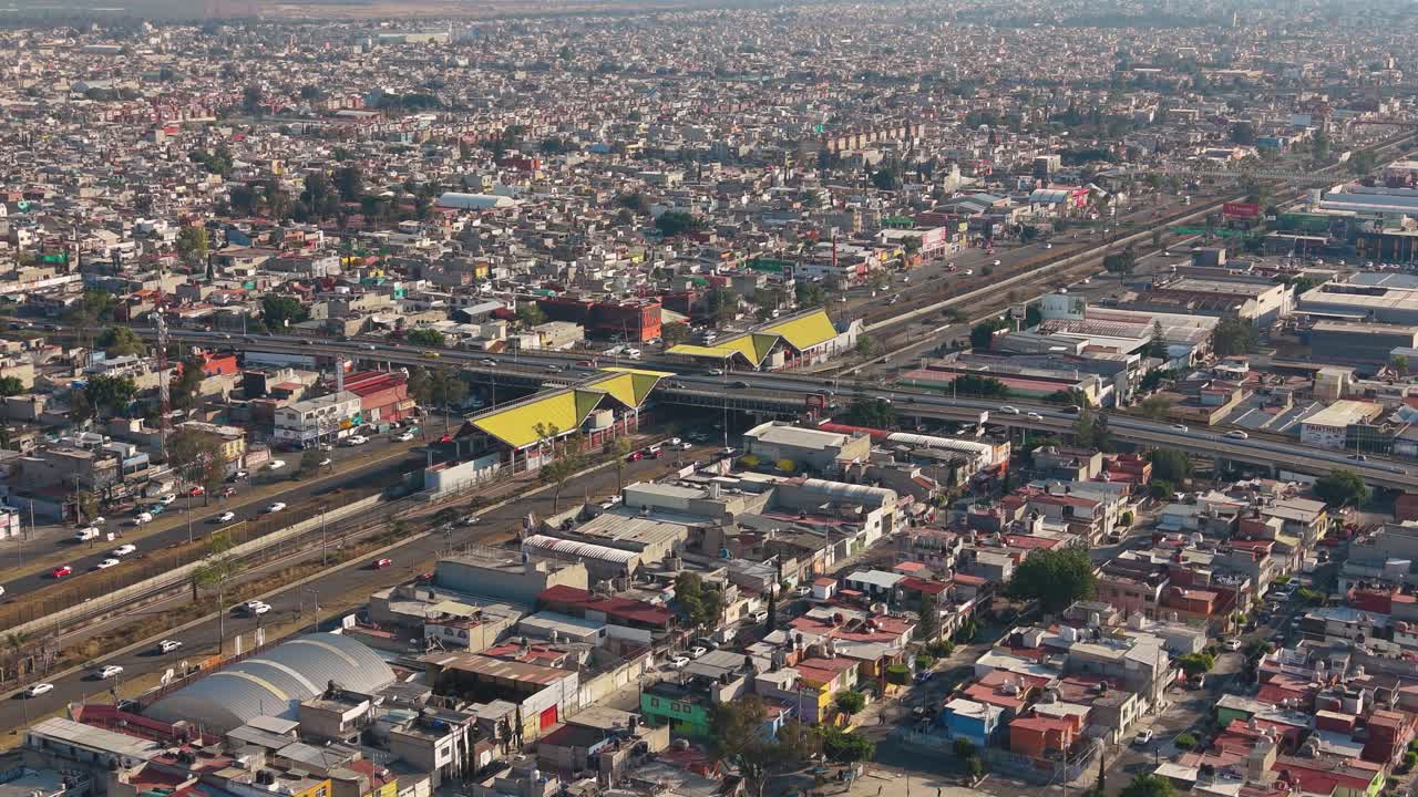 Ecatepec mahalle sokaklarında, yoğun çatılar ve hareketliliğin olduğu alçak drone geçişi.