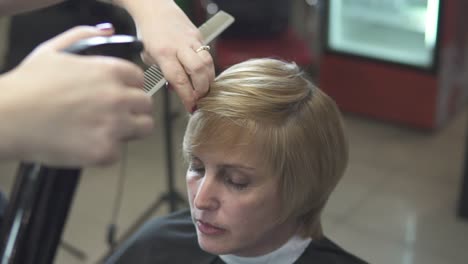 junge frau, die ihre haare im friseursalon anzieht. friseur-stylist bei der arbeit. friseur, der ihre haare nass macht.