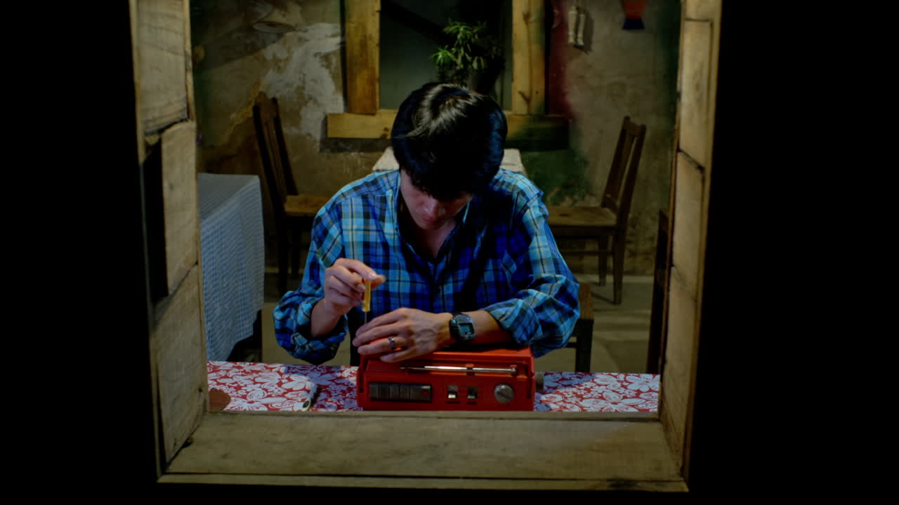 테이블 위의 라디오를 해체하는 기술자, 정적 클로즈업