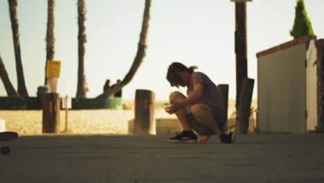 skater boy doing trick and falls down in coastal area of los angeles