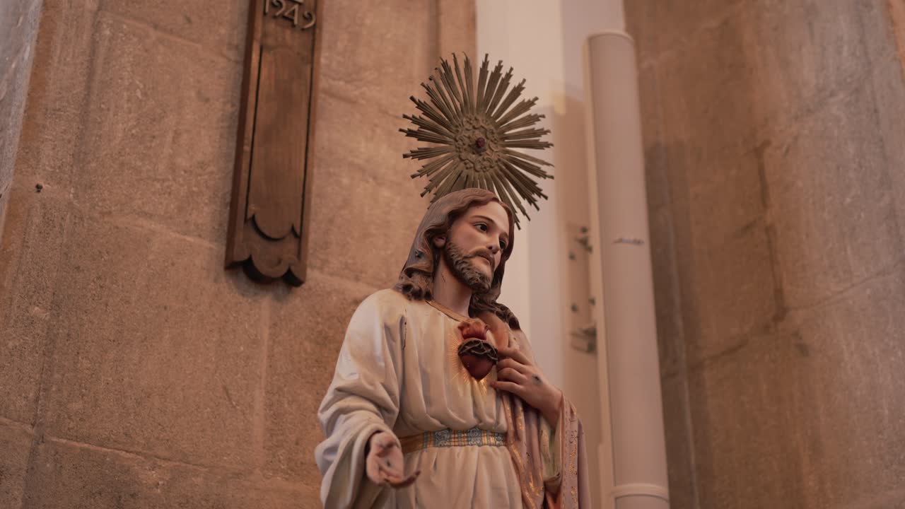 Statue of Jesus with sacred heart in quiet church interior soft natural light
