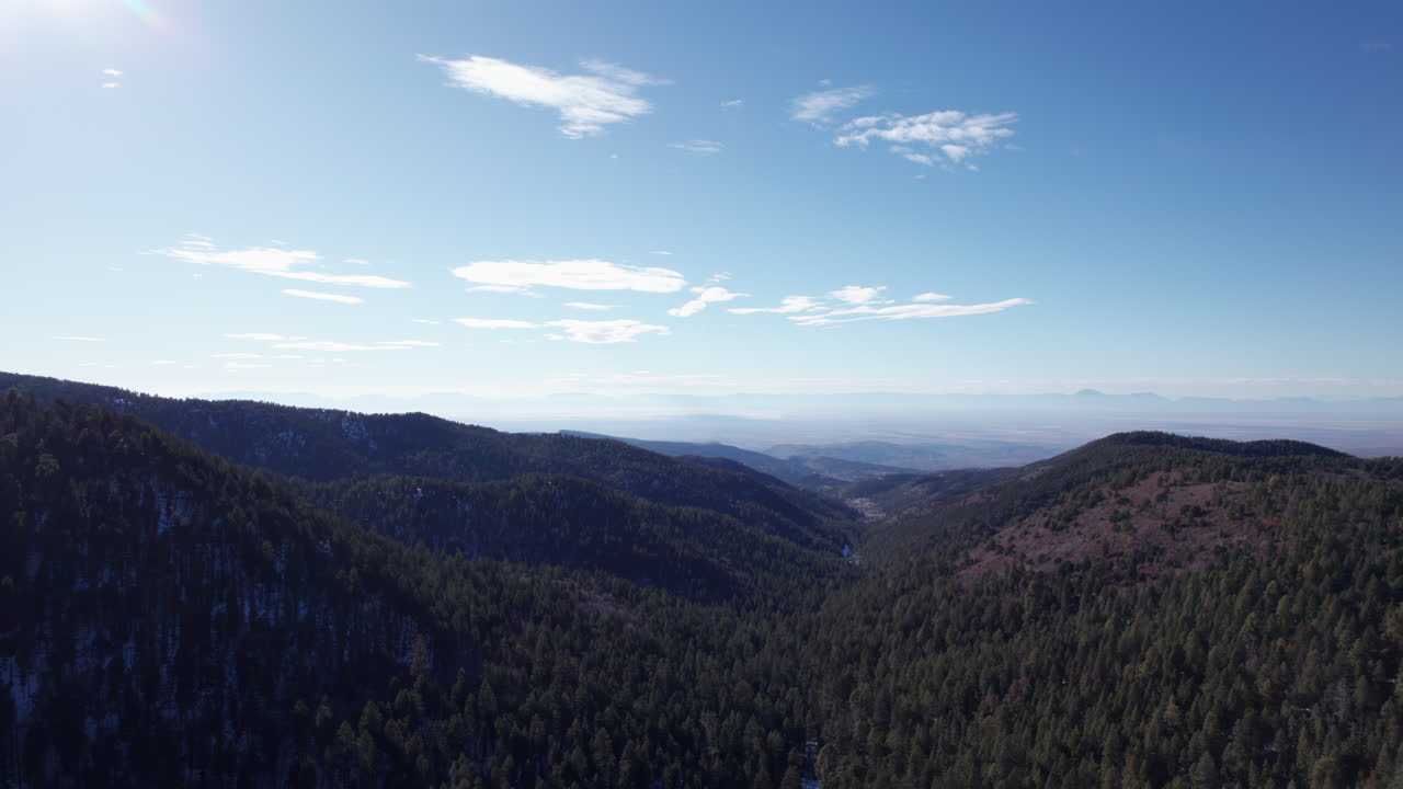 High angle aerial view pull out of the mountains and valleys near Cloudcroft, New Mexico