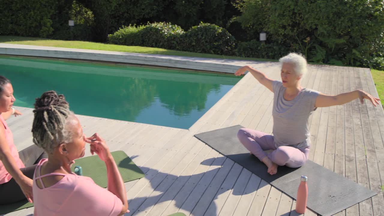 Senior African American instructor leading diverse women breathing, reaching on mats, copy space