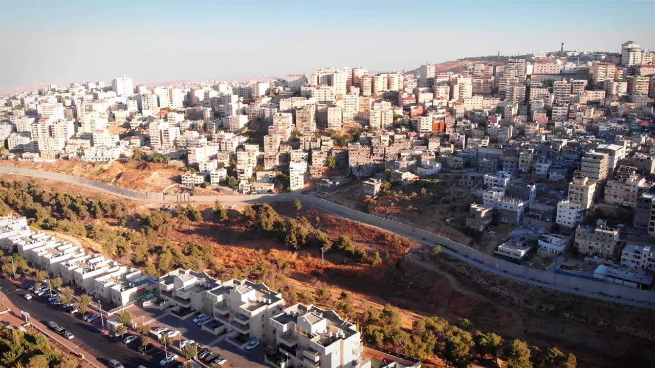 Aerial View of a Densely Built Cityscape on a Hillside with a Barrier Wall