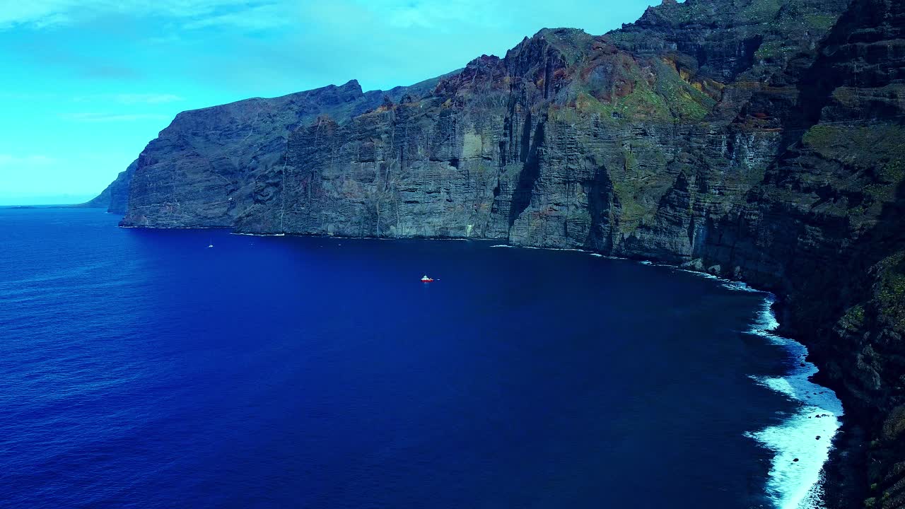 테네리페 섬, 스페인의 높은 산 아래 부드러운 파도와 푸른 바다 물