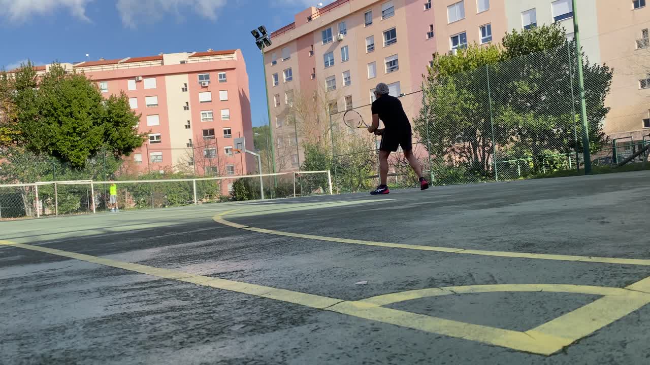 pelota de tenis y viejo tenista haciendo un juego fantástico en la cancha de lisboa, portugal