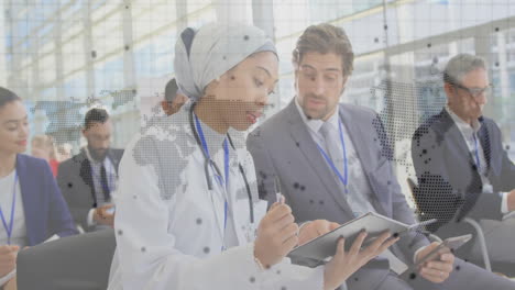 Medical professional taking notes with world map animation over business meeting