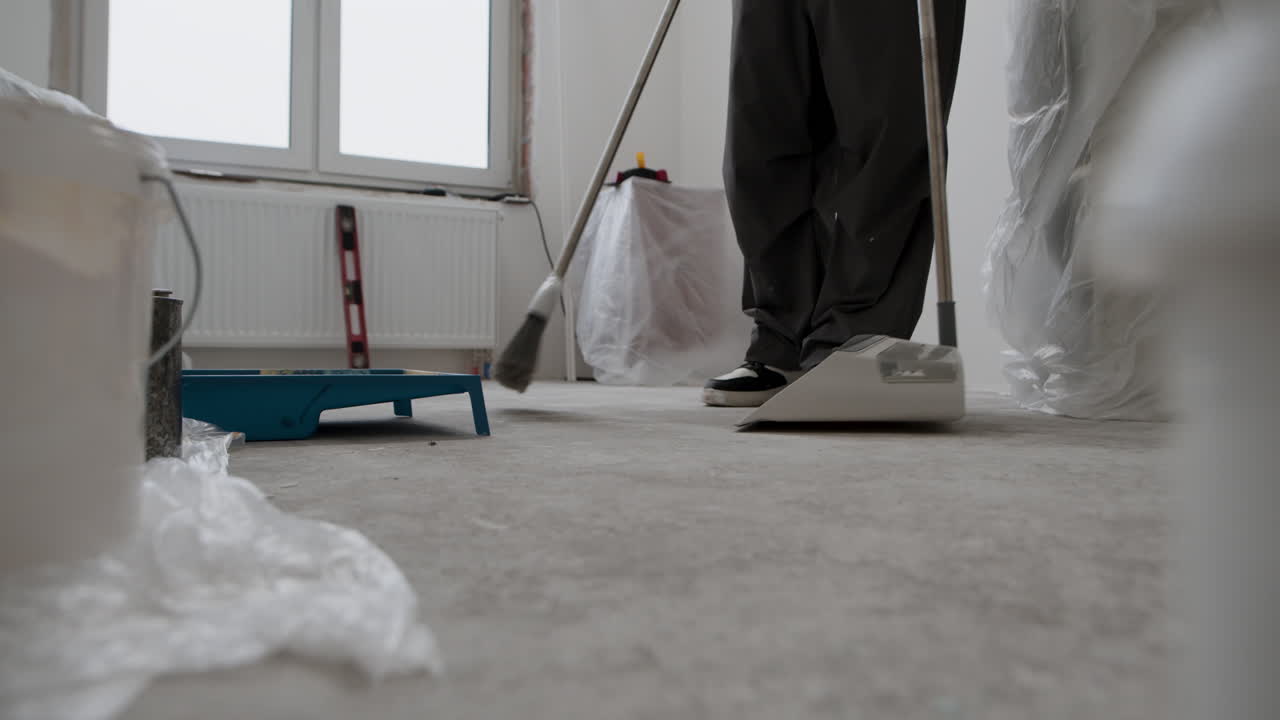 Construction Worker Sweeping Up After Renovation