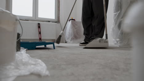 construction worker sweeping up after renovation