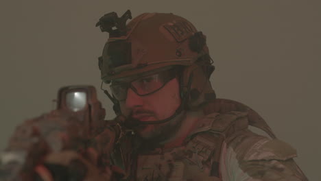 focused man in protective helmet and uniform taking aim