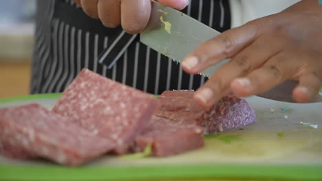 Schneiden-Und-Schneiden-Von-Salami-Zum-Servieren-über-Gehacktem-Antipasti-Salat---Serie-Antipasti-Salat