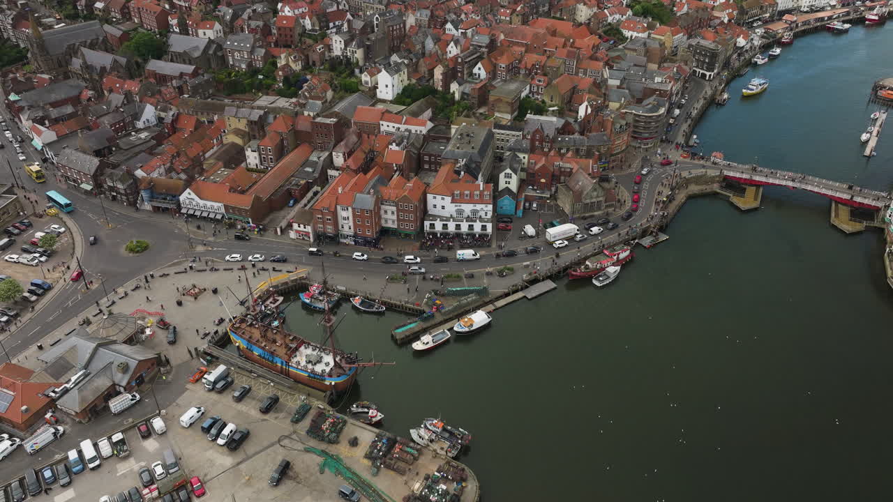 el puerto de whitby en inglaterra con barcos y edificios históricos, un bullicioso día de verano, vista aérea