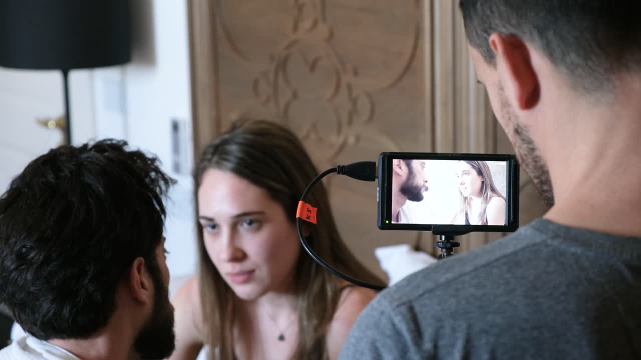 Behind the scenes of a film a young couple having a serious breakup talk in bed. 4K