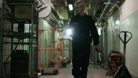 Female-safety-guard-with-flashlight-in-a-warehouse