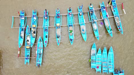 Overhead-sliding-drone-shot-of-traditional-fisherman-boat-anchored-on-the-harbor---Baron-Beach,-Indonesia