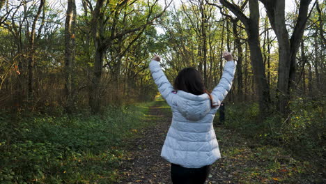 una mujer asiática caminando por un camino arbolado