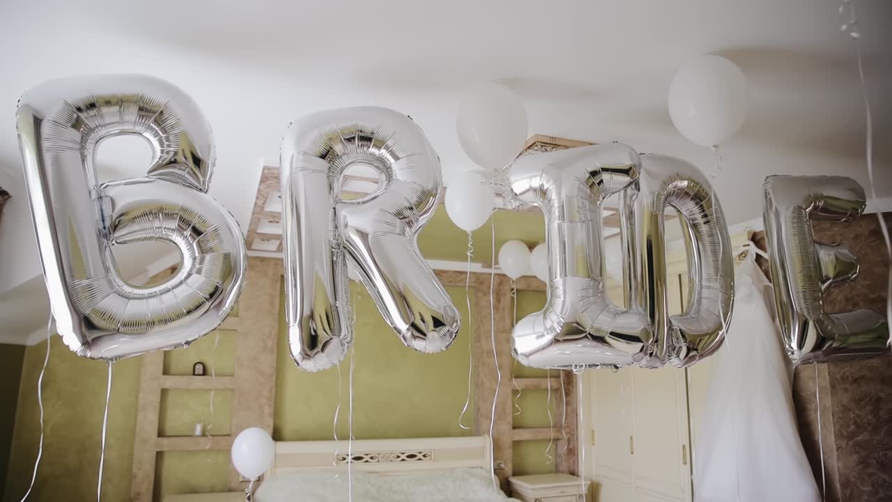 mañana de bodas, la palabra novia de globos volando en el centro del dormitorio
