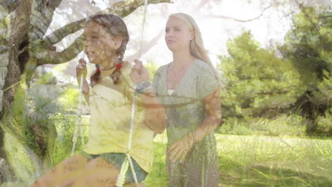 girl pushed on a swing by her mother. montage with trees