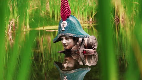 Statue-of-Napoleon-with-colorful-hat-covered-in-water-to-shoulder-level,-zoom-out-view