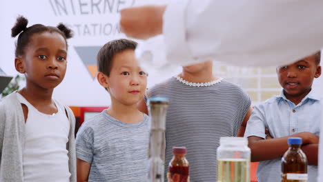 los niños ven el experimento con el quemador bunsen en el centro de ciencias.