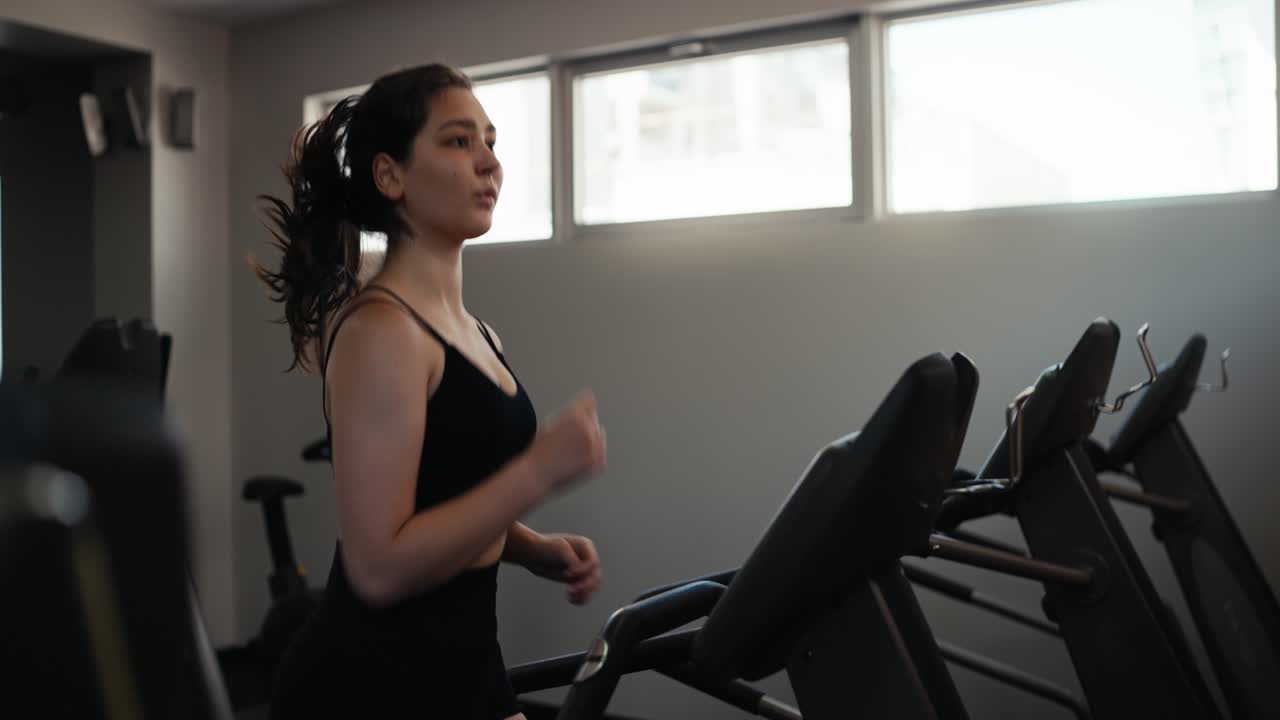 una donna che corre su un tapis roulant in una palestra
