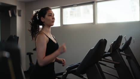 vrouw die op de loopband loopt in de sportschool