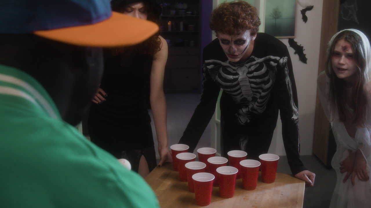 People playing beer pong in Halloween costumes