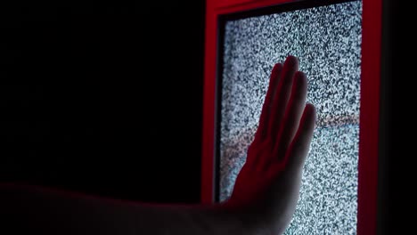 human hand touching old retro television screen with ripples, wavy flowing damaged signal. close-up of broken old-fashioned tv with noise, bad signal reception, cinematography concept