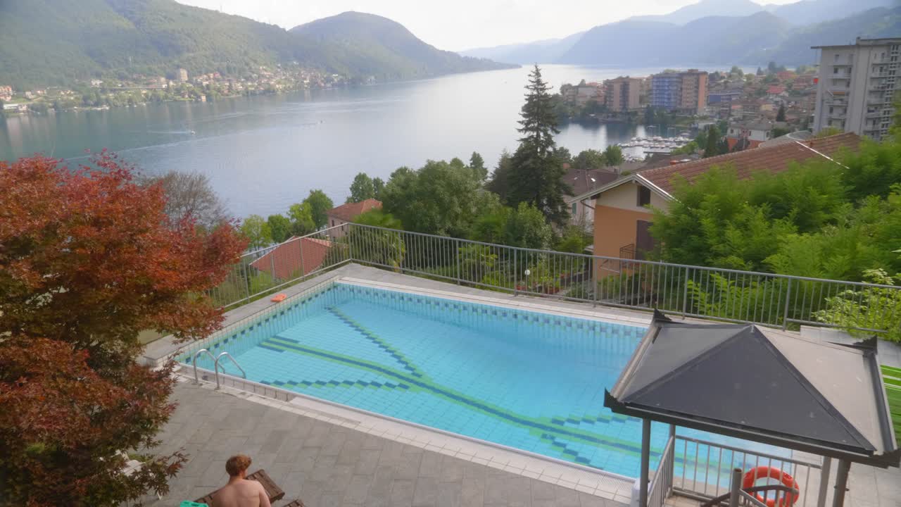A young man jumps into a pool with a beautiful view
