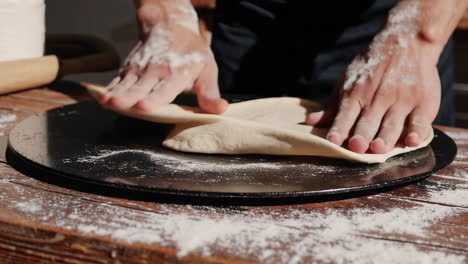 close-up of hands preparing pizza dough
