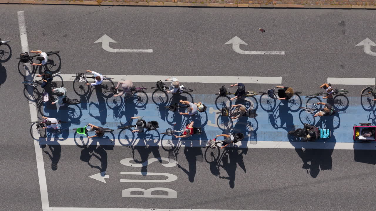 Aerial drone view of a large group of cyclists waiting at a traffic light in Copenhagen, Denmark