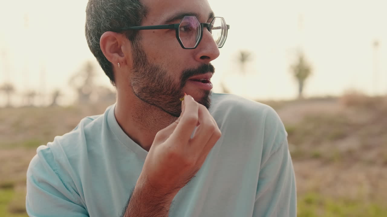 Friends Enjoying a Picnic in the Park, focus on the young man