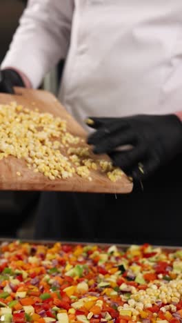 chef preparando un plato de verduras mixtas con maíz