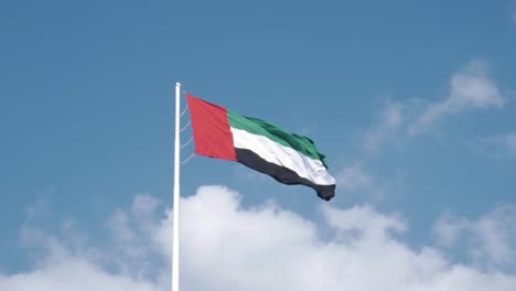 uae flag waving with strong wind with pride on a post
