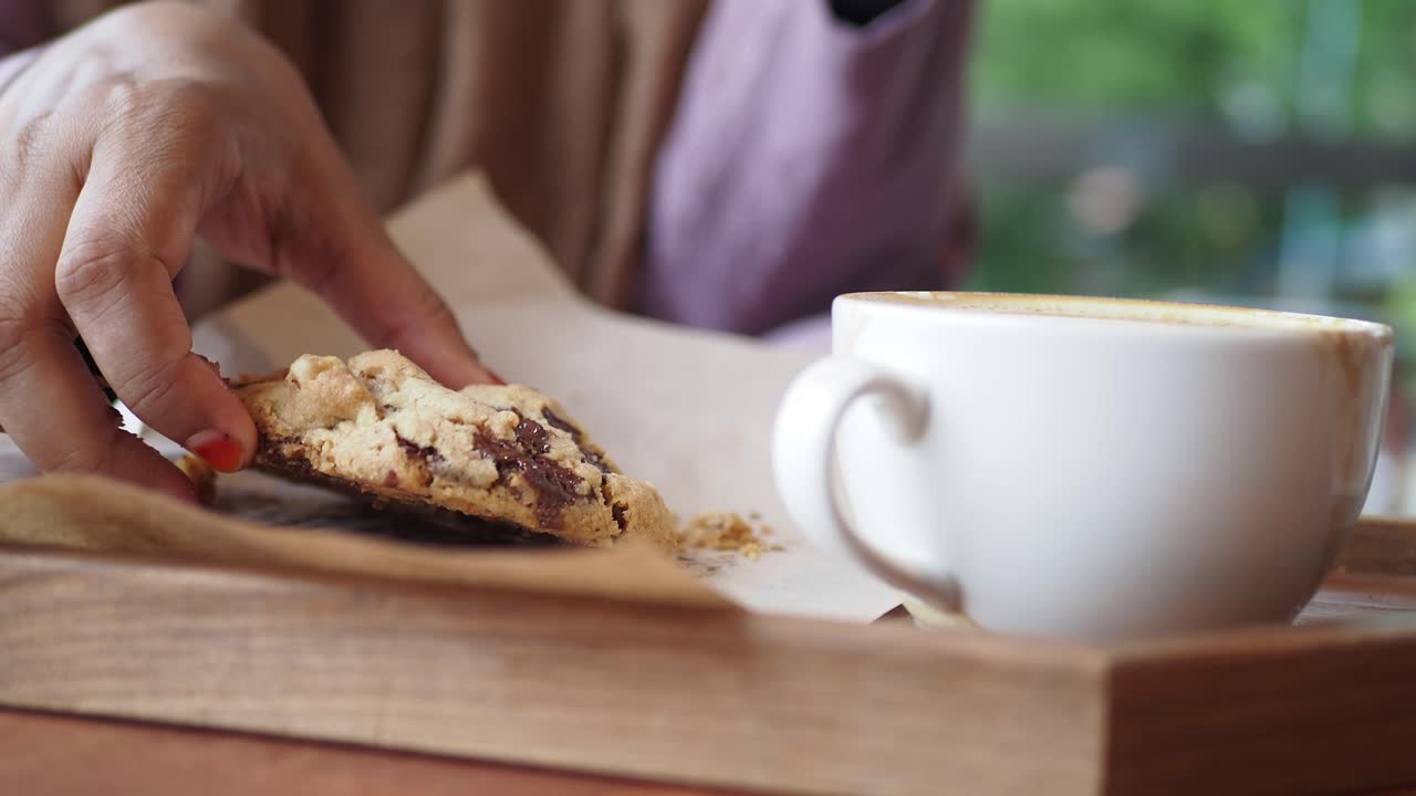 Woman enjoying a chocolate chip cookie and coffee