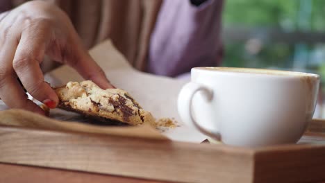 woman enjoying a chocolate chip cookie and coffee