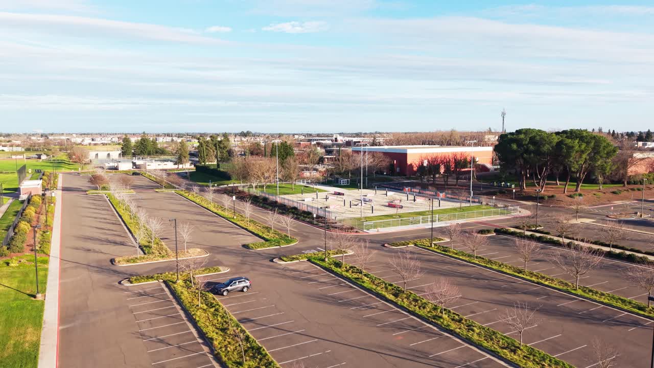 El dron sobrevuela el Cosumnes River College mientras la cálida luz del día se desvanece, iluminando tejados y pasarelas, y la tarde de Sacramento añade profundidad y claridad al diseño del campus.