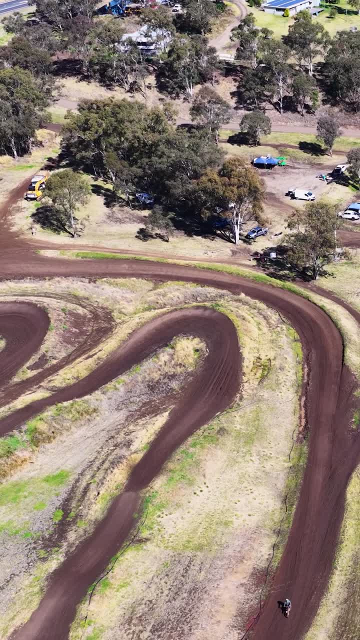 Imagem aérea de drone de motos de motocross navegando em uma pista curva na Austrália.