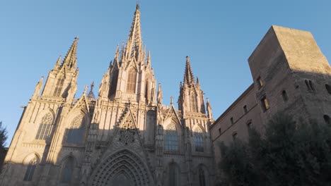 the majestic cathedral of barcelona showcases its intricate gothic architecture, illuminated by warm sunlight under a clear blue sky.