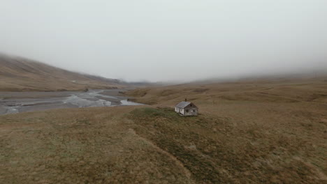 Slow-dolly-shot-towards-abandoned-house-in-empty-countryside,-foggy-scenery