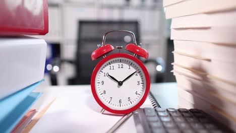 despertador rojo para las diez en el escritorio con documentos