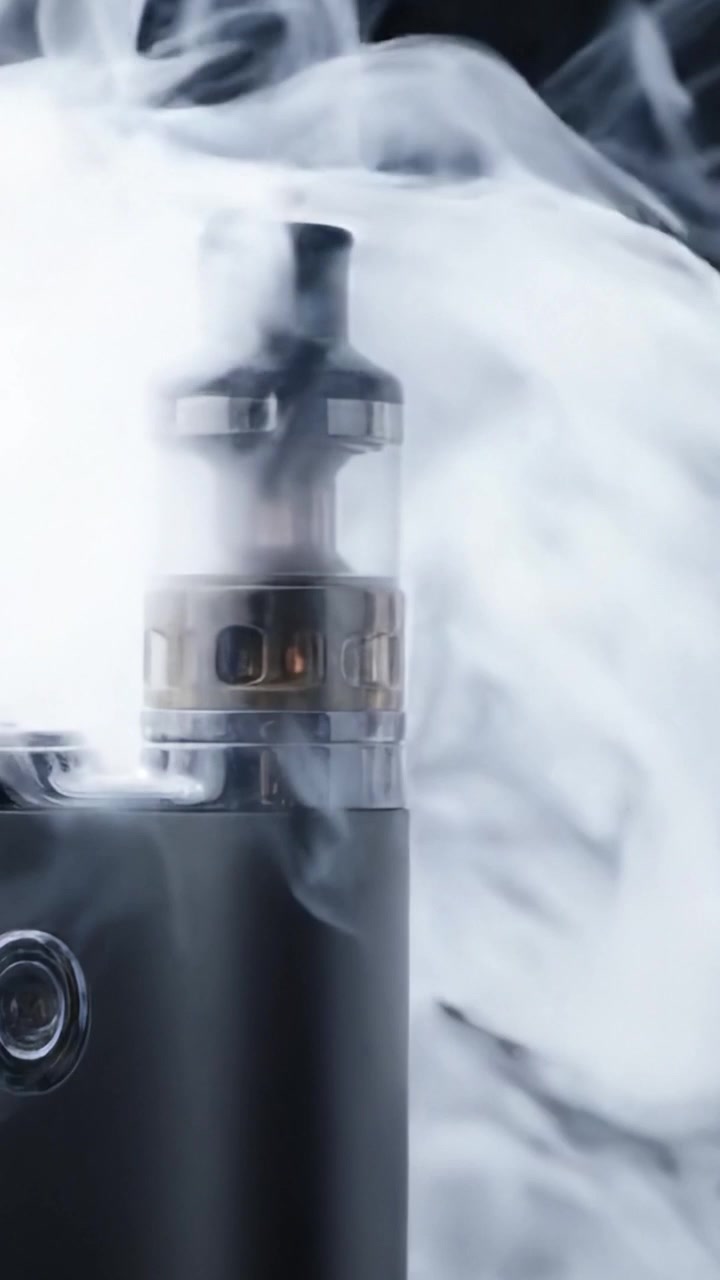 A Glimpse into the World of Vaping: An Elegant Black Vape Device Surrounded by Ethereal Clouds of Smoke Captured in Stunning Detail