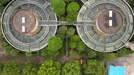 drone aerial view of sewage water treatment plant with storage tanks, trees