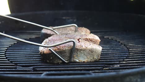 Flipping-salmon-steaks-of-the-grill-to-sear-the-other-side---isolated-close-up