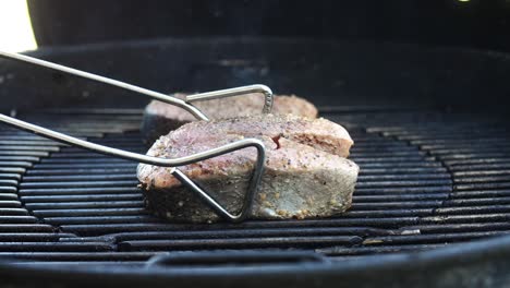 flipping salmon steaks of the grill to sear the other side - isolated close up