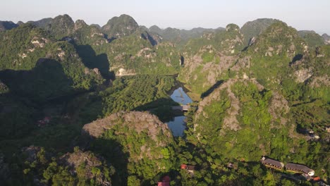 aerial tilt up view across sunrise light across ninh binh mountains in vietnam