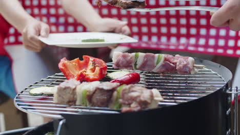 close-up of unrecognizable man putting steak from grill on plate