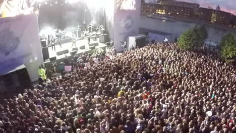 Toma-Aérea-De-La-Actuación-De-Una-Banda-De-Rock-Y-Una-Multitud-De-Fans.