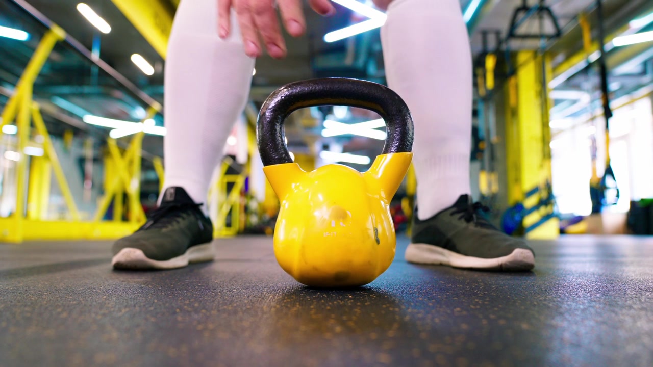 Persona che scambia un hamburger con una kettlebell in palestra